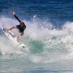 athetic surfer jumping over a wave