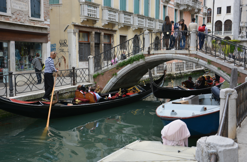 Gondolieri pass bridges in Venice